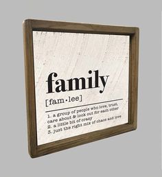 a family definition sign mounted on a wall in a wood frame with text below it