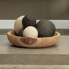 a wooden bowl filled with black and white balls