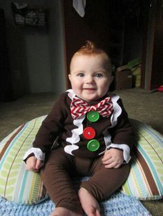 a baby sitting on top of a bean bag chair wearing a brown and red christmas outfit