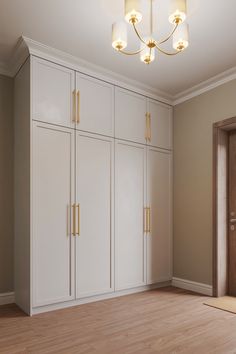 an empty room with white cabinets and wood floors