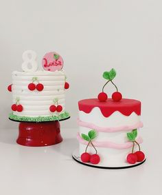 two cakes decorated with cherries and the number eight on each one are sitting side by side