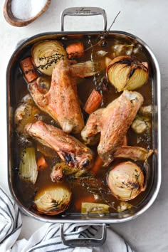 chicken, potatoes and carrots in a roasting pan on a white counter top