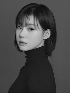 a black and white photo of a woman with short hair wearing a turtle neck sweater