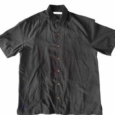 This Tommy Bahama shirt in black is made of 100% silk and features short sleeves with button closure, a collared neckline, and a regular fit. The shirt is perfect for any occasion and can be dressed up or down. The accents include button detailing, making it a versatile piece for any wardrobe. The shirt is a size large and is an all-seasons item that can be worn year-round. The point collar style adds a touch of sophistication to any outfit. This shirt is perfect for any man looking for a stylis Black Buttoned Summer Shirt, Summer Black Shirt With Buttons, Casual Black Collared Shirt, Casual Black Shirt With Collared Neckline, Black Buttoned Shirt For Summer, Black Summer Shirt With Buttons, Black Shirt With Button Closure For Summer, Black Button Closure Shirt For Summer, Black Short Sleeve Shirt For Summer