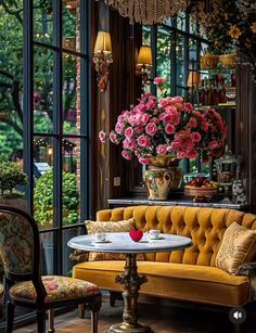 a living room filled with lots of furniture and flowers in vases on the windowsill