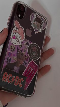 someone is holding their phone case with stickers on it