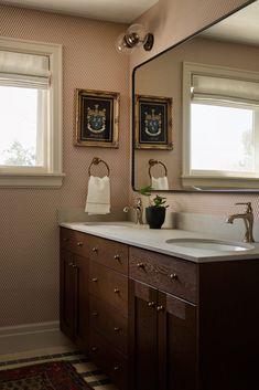 a bathroom with two sinks and a large mirror above it's countertop area