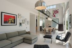 a living room filled with furniture and pictures on the wall next to a stair case