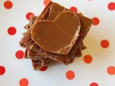 a heart shaped piece of chocolate sitting on top of a white and red polka dot table cloth