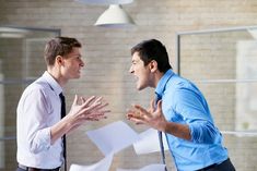 two men are talking in an office with papers flying around them and one is holding his hands out to the other man