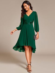 a woman wearing a green dress and heels