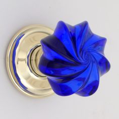 a blue glass door knob on a white wall with a silver handle and an intricate design