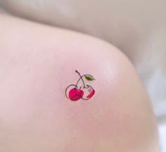 a small cherry tattoo on the back of a woman's stomach