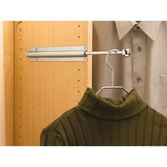 a green shirt is hanging on a metal hanger in front of a wooden door