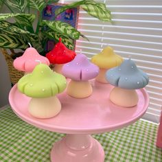 there are many small candles that are on the cake platter in front of a potted plant