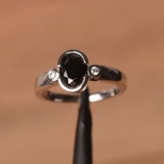 a black diamond ring sitting on top of a wooden table