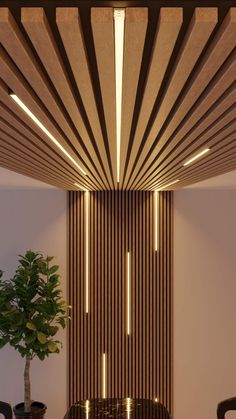 an elegant dining room with wood paneling and lights on the ceiling, along with a potted plant