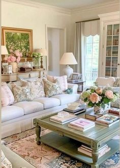 a living room filled with lots of furniture and flowers on top of a coffee table