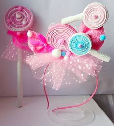 two pink and blue lollipops sitting on top of a white table next to each other