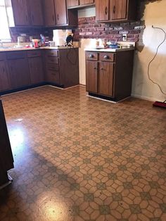 an empty kitchen with wooden cabinets and tile flooring in the middle of the room