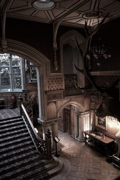 an ornately decorated staircase with chandelier and stairs leading up to the second floor