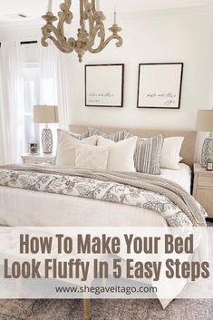 a bedroom with white bedding, chandelier and pictures on the wall above it