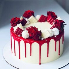 a cake with red and white icing on it is sitting on a platter