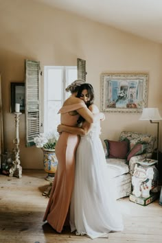 two women hugging each other in a living room