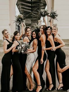 a group of women standing next to each other in front of a white and black building