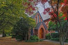 an old church surrounded by trees and foliage