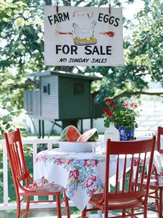 an outdoor table with chairs and a sign hanging from the ceiling that says farm eggs for sale