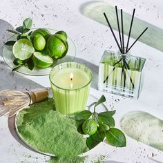 limes and candles on a table with green powder