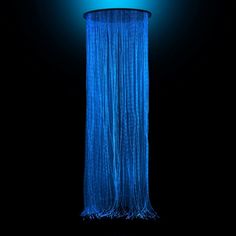 a blue shower head in the dark with water flowing down it's sides and lights on