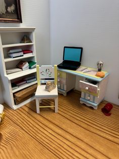 a doll house desk and chair with laptop computer on the top shelf next to it