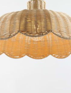 a wicker chandelier hanging from a ceiling fixture with scalloped edges