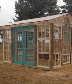 a small wooden shed with windows on the side