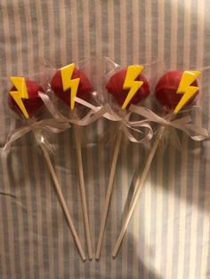 four lollipops wrapped in cellophane and decorated with lightning symbols