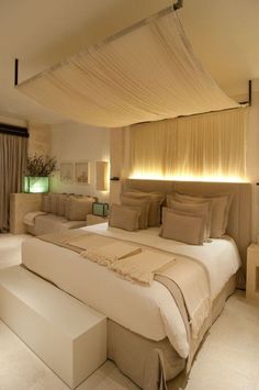 a large bed sitting in the middle of a bedroom next to two tables and lamps