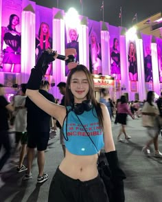 a woman with headphones on taking a selfie in front of a building at night