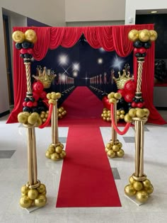 a red carpet and two gold poles with balls on them