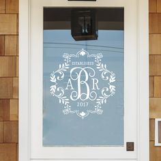 the monogrammed door is decorated with an elegant wreath