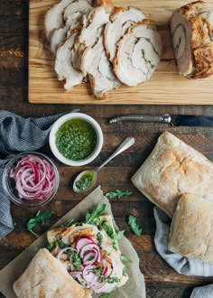 sliced meat and vegetables on cutting board next to bread