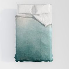 an unmade bed with white sheets and green ombreath