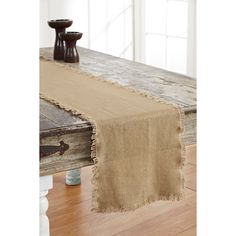 the table runner is made from burlocked linen and has fringed edges