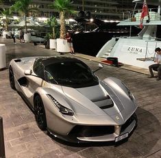 a silver sports car parked in front of a boat