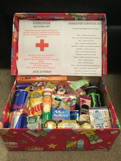 an open red box filled with lots of food and drinks on top of a carpeted floor