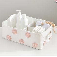 a white and pink polka dot basket with soap, toothbrushes and lotion