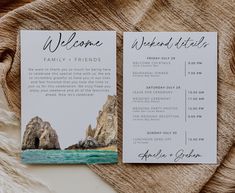 two wedding programs on top of a blanket next to each other with the ocean and rocks in the background