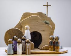 a group of wooden figurines sitting on top of a table next to a rock