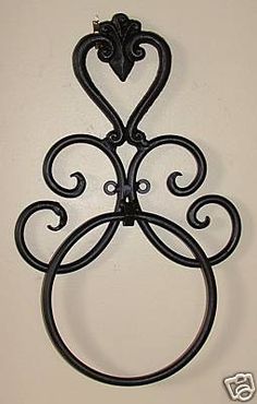 a metal wall hanging on the side of a white wall with a heart shaped design